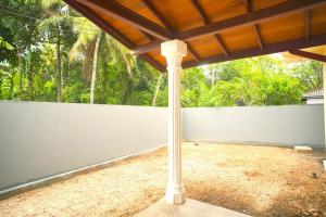 eine Veranda mit einem weißen Zaun und einem Pfosten in der Unterkunft Sanmi Runway View Resort in Kimbulapitiya