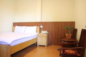 a bedroom with a bed with a wooden head board at Thu Van Apartment in Xuan An