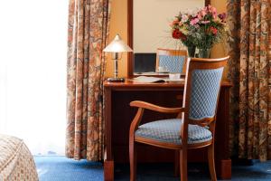 a desk with a chair and a vase of flowers at Union Hotel Prague in Prague