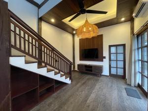 CemagiVilla Kayu Sungkai的客厅设有楼梯和平面电视。