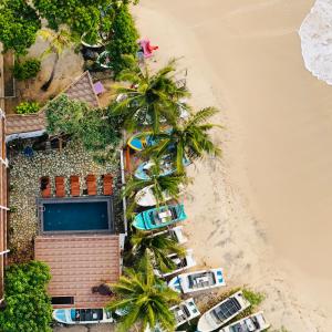 an aerial view of a beach with palm trees and cars at LIYA BEACH- Luxury Boutique Hotel in Ahangama in Ahangama
