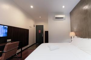 a bedroom with a large white bed and a tv at T+ Hotel Sungai Korok in Alor Setar