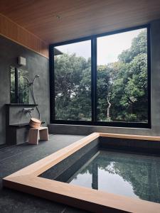 een huis met een zwembad en een groot raam bij 2R Yakushima in Yakushima