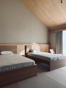 een slaapkamer met twee bedden en een raam bij 2R Yakushima in Yakushima