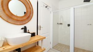 Un baño con un lavabo blanco y un espejo. en Dune Sanctuary, en Plettenberg Bay