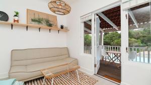 Una sala de estar con un sofá y un balcón. en Dune Sanctuary, en Plettenberg Bay