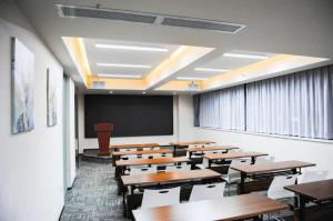 ein Klassenzimmer mit Holztischen und einer Tafel und ein Klassenzimmer in der Unterkunft Jinjiang Inn Select Xi'an Dayan Tower Zhuque Street Chengshi Lifang in Xi'an