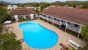 Una vista aérea de una gran piscina frente a dos edificios. en Dune Sanctuary, en Plettenberg Bay