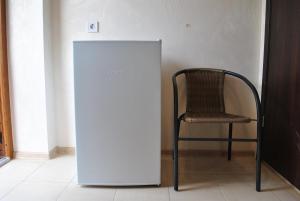a white refrigerator and a chair in a room at Uytno in Chornomorsk