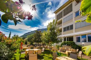 a patio with tables and chairs in front of a building at Hotel Residence Pernhof in Termeno