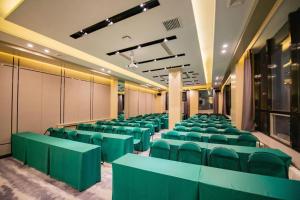 a conference room with green chairs in a building at Echarm Hotel Changchun Yiqi Automotive Trade City Wanda in Changchun