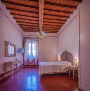 a bedroom with a bed and a wooden ceiling at de' Montetini in Arezzo