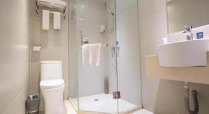 a bathroom with a shower and a toilet and a sink at City Comfort Inn Wuhan Zhongnan Hospital Shuiguohu Metro Station in Wuhan +89 photos