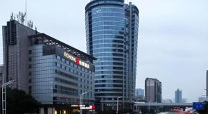 a tall glass building with a sign on it at Echeng Hotel Changsha Evening News in Changsha