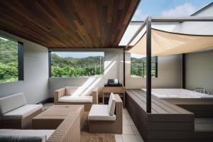 a bathroom with a tub and a sink and a bath tub at Sanctuary Villa & Sauna Ogimi by Relapool in Banchi