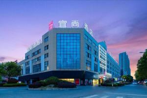 a large building with a sign on top of it at Echarm Hotel Yingshang High-speed Railway Station Wuzhou Wanhui Plaza in Jingzhuang