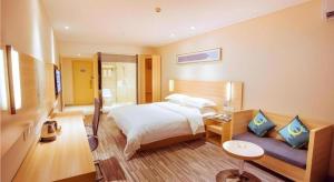 une chambre d'hôtel avec un lit et un canapé dans l'établissement City Comfort Inn High-tech Development Zone Dawang Plaza Wandu, à Xiahuangtang