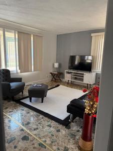 a living room with a flat screen tv and furniture at Master Bedroom with Attached SunRoom and Attached Patio in Richmond