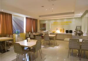 a restaurant with tables and chairs and a kitchen at City Comfort Inn Guilin Xiangbi Mountain Park in Guilin