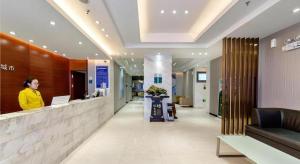 a woman standing at a counter in a lobby at City Comfort Inn Guilin Two Rivers and Four Lakes Sun and Moon Shuangta in Guilin