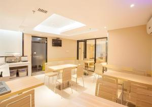 a room with tables and chairs and a laptop at City Comfort Inn Nanning Chaoyang Square Zhongshan Road Food Street in Nanning