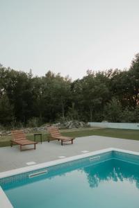 two chairs sitting next to a swimming pool at Arusha Diplomat Hotel & Conference in Marombosa