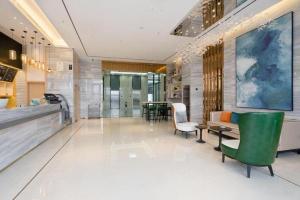 a lobby with a couch and chairs in a building at City Comfort Inn Dongguan Gaobu Avenue in Dongguan