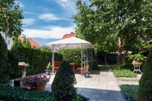 einen Garten mit einem Tisch und einem Sonnenschirm in der Unterkunft Penzion Rossini in Franzensbad
