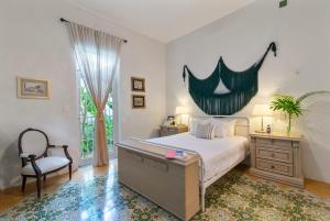 a bedroom with a bed and a desk and a chair at Casa Damiana, Colonial Charm with Private Pool in Mérida +23 photos