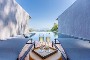 two glasses of wine sitting on a table on a boat at Stunning Views - Villa Maan Ingfah (VMI1) in Ban Na Kok
