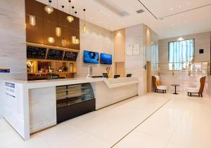 a woman sitting at a counter in a kitchen at City Comfort Inn Kunming Xinluojiu Bay Guangju Road in Kunming