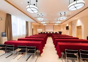 a conference room with red tables and chairs at City Comfort Inn Kunming Xinluojiu Bay Guangju Road in Kunming