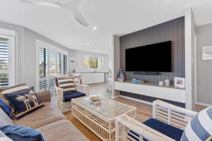 a living room with a couch and a tv at Salt and Sea on Marine in Kingscliff