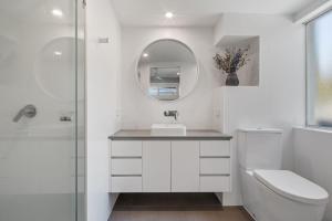 a white bathroom with a sink and a mirror at Salt and Sea on Marine in Kingscliff +15 photos