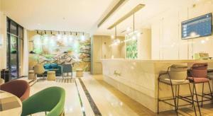 a restaurant with a bar with chairs and tables at Magnotel Hotel Huangshan Scenic Area Transfer Center in Huangshan Scenic Area