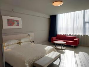 Un dormitorio con una cama y un sofá rojo. en Jinjiang Inn Hengshui Anping, en Anping 6 fotos más