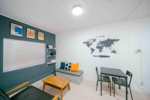 泉佐野Transit Hostel的一间设有一张桌子的客房,墙上挂着一张世界地图