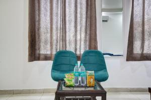 a green chair with water bottles on a table at Hotel King Near Delhi Airport in New Delhi