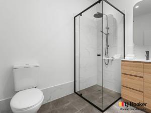 a bathroom with a toilet and a glass shower at Margies in Iluka +10 photos
