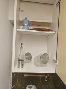 a cupboard with utensils and a bottle on it at Home Jordy di Piero Giordanella in Brucoli +22 photos