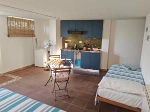 a kitchen with blue cabinets and a table and chairs at Home Jordy di Piero Giordanella in Brucoli