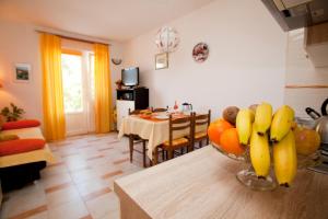 a kitchen with a bowl of fruit on a table at Apartments Marija in Vrbnik