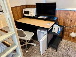 a desk with a computer and a chair in a room at i GARDEN in Minami Alps