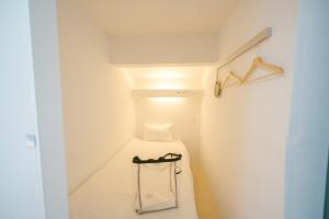 a white room with a stairway with a stool at TRANSIT HOSTEL Cafe and Bar in Izumi-Sano