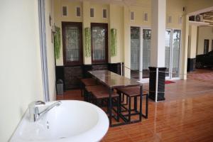a bathroom with a sink and a table and chairs at House of A Syariah Kedamaian in Bandar Lampung