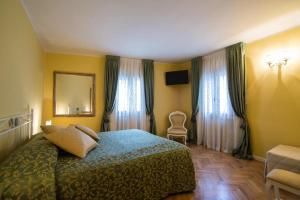 Schlafzimmer mit einem Bett, einem Stuhl und Fenstern in der Unterkunft B&B La Pescadora in Valeggio sul Mincio