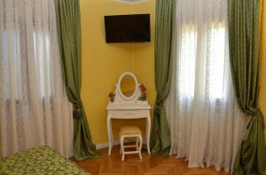 Schlafzimmer mit einem Tisch, einem Spiegel und Vorhängen in der Unterkunft B&B La Pescadora in Valeggio sul Mincio