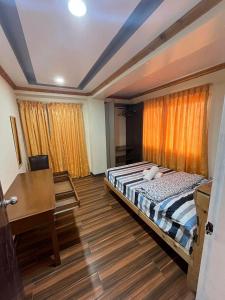 a bedroom with a bed and a desk in it at TPRC Residences in Baguio