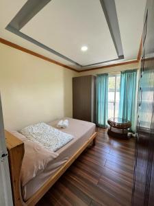a bedroom with a bed in a room with blue curtains at TPRC Residences in Baguio