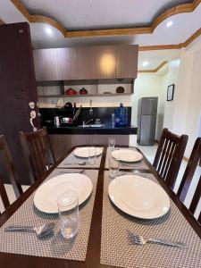 a dining room table with plates and glasses on it at TPRC Residences in Baguio